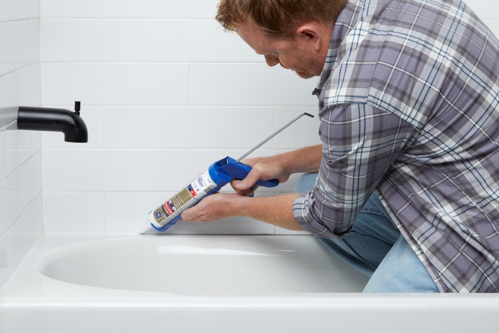 Applying sealant in a bathroom.